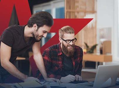 Two men working together on a laptop.