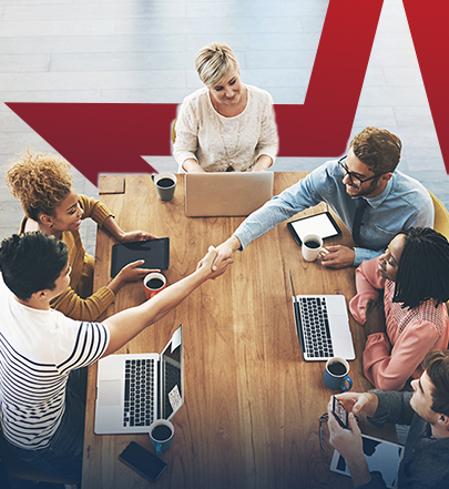 Business sales team sitting around table on laptops.